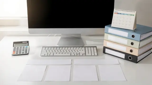 Kalender, Taschenrechner und Steuerunterlagen auf einem Schreibtisch zum Fristenunterschied bei der Einkommensteuer.