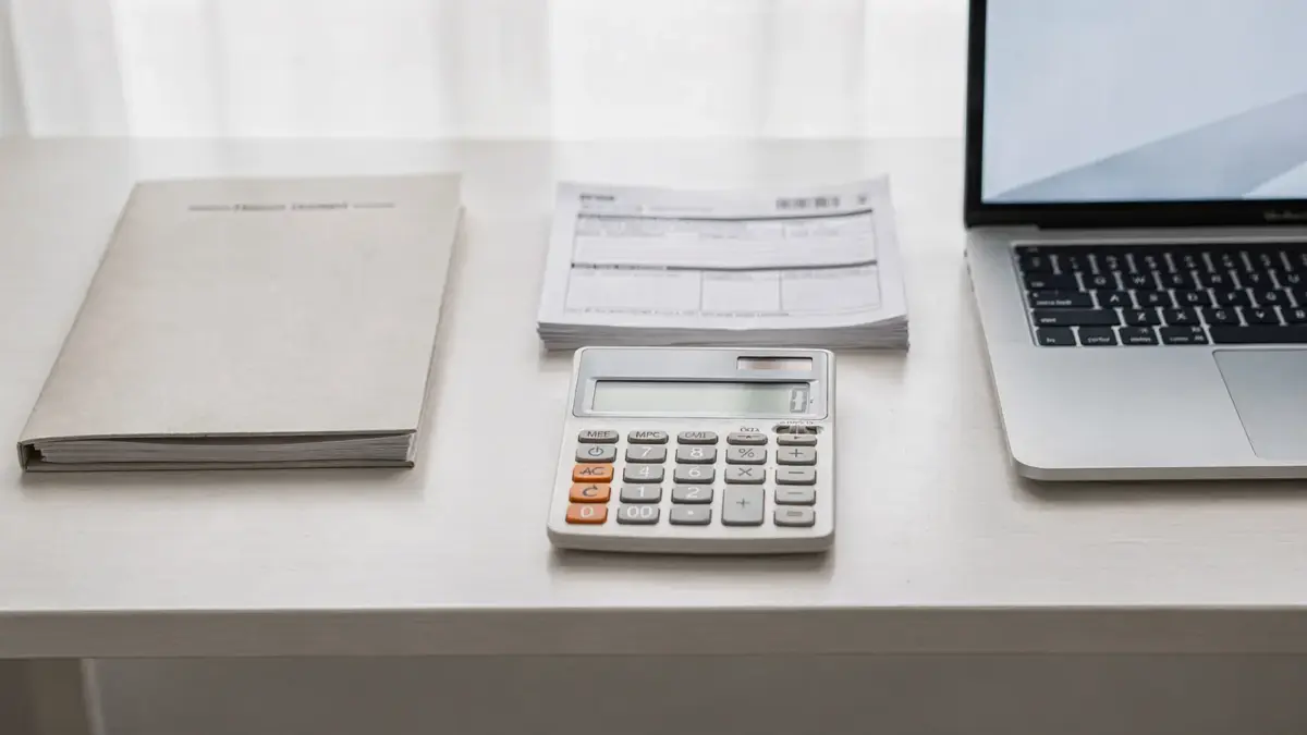 Steuerunterlagen, Rechner und Laptop zu Betriebsrente und Steuerabzug auf einem Schreibtisch